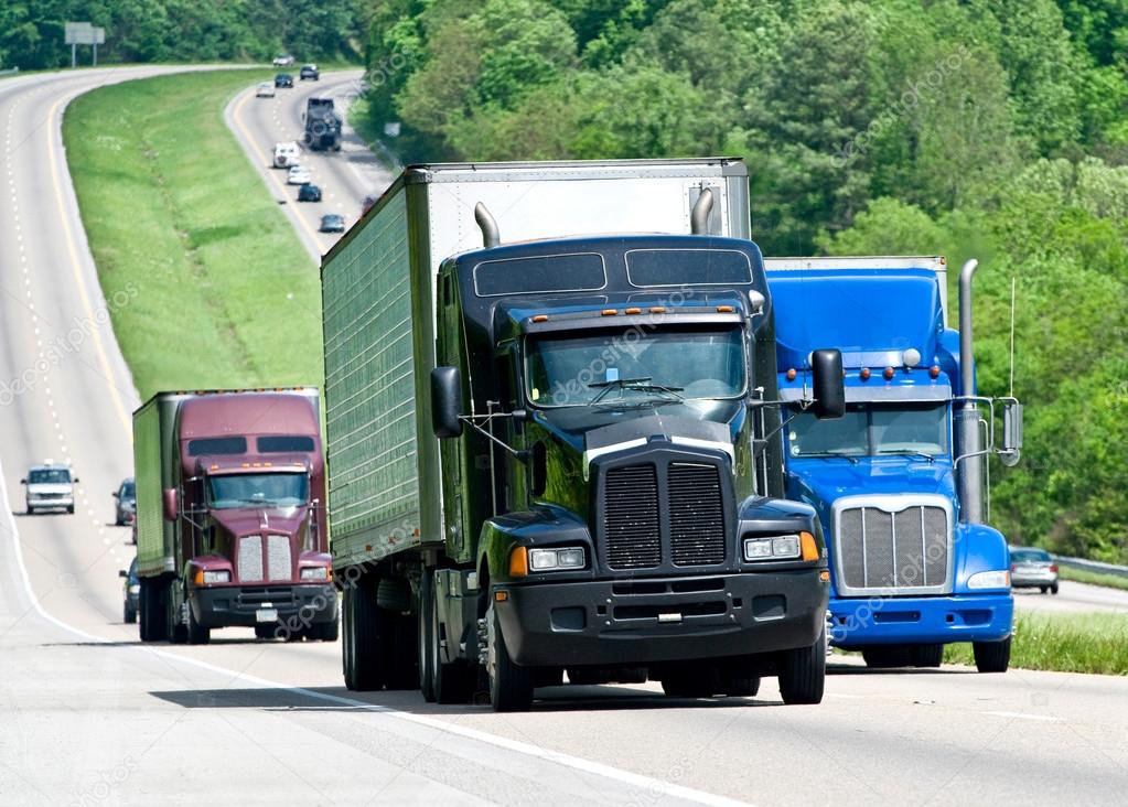 Big Trucks Moving Down A Long Highway