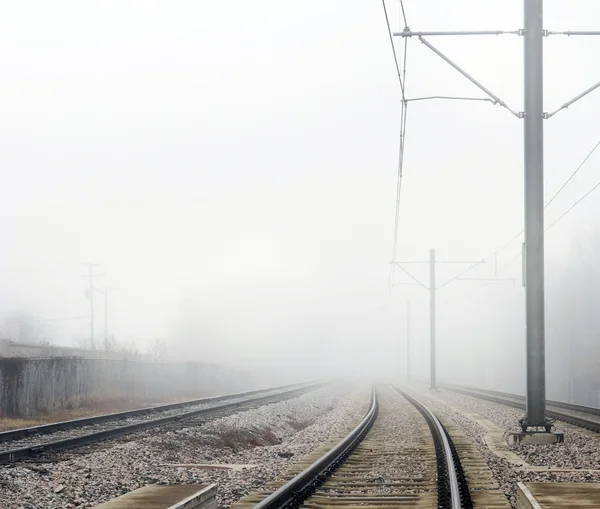 Pistes de train disparaissant dans le brouillard Concept — Photo