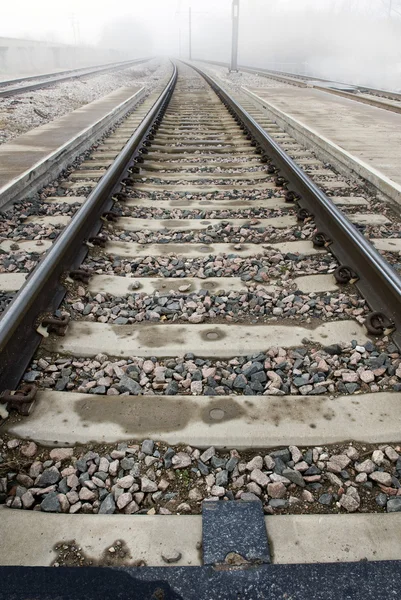 Faixas de trem desaparecendo no conceito de nevoeiro — Fotografia de Stock