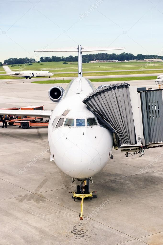 Airplane Being Serviced While Another Takes Off