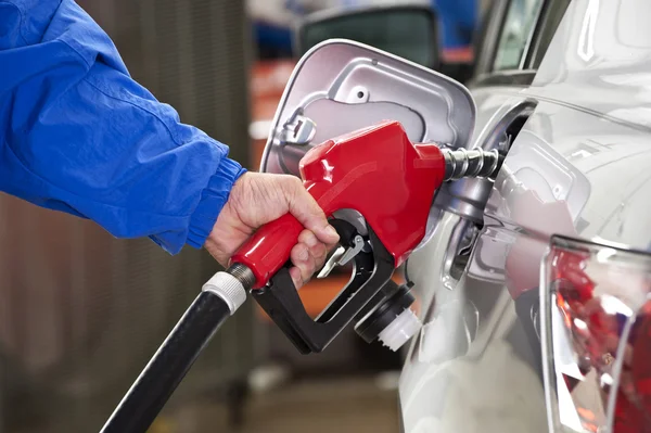 Uomo pompaggio benzina con ugello rosso — Foto Stock