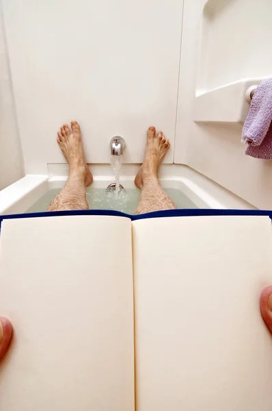 Manos sosteniendo libro en blanco en la bañera —  Fotos de Stock