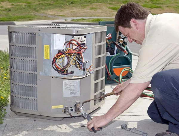 Klimaanlage reparieren Mann überprüft Freon-Pegel Stockfoto