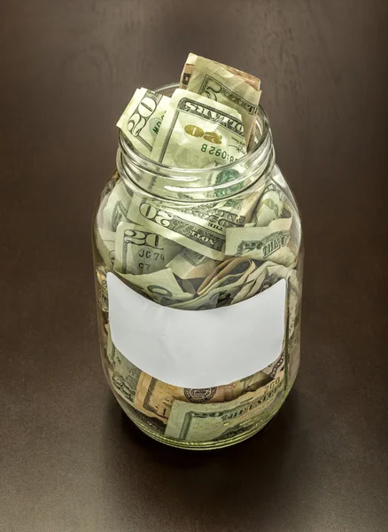 Frasco de dinheiro transparente com etiqueta em branco — Fotografia de Stock