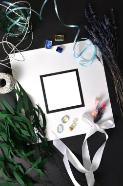 Arka plan düz beyaz çerçeve ve dekorlu siyah bir çarşaf üzerinde bir sayfa kağıt. Dikey