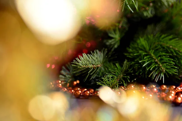 Fondo de invierno para Año Nuevo y Navidad, ramas de abeto, oropel, decoración de árboles de Navidad, cuentas de naranja, luces borrosas. — Foto de Stock