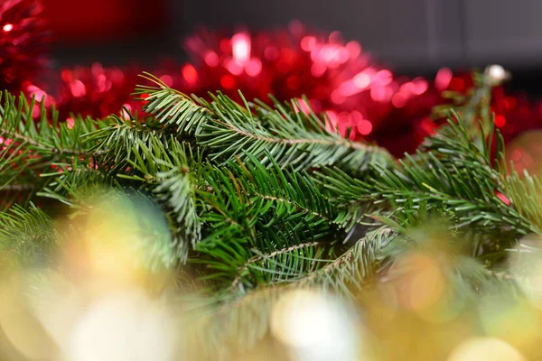 Background with coniferous branches of fir and pine, yellow and red tinsel for decorating the New Year tree, the background is blurred. — Stock Photo, Image