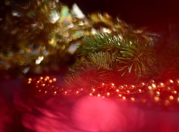 Orange beads with round beads to decorate the Christmas tree, close-up against a background of blurred red light from the lamps. — Stock Photo, Image