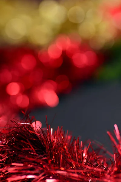 Abstract background red tinsel for the Christmas tree, blurred background colored lights. — Stock Photo, Image