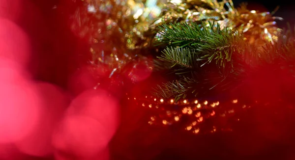 Orange beads with round beads to decorate the Christmas tree, close-up against a background of blurred red light from the lamps. — Stock Photo, Image