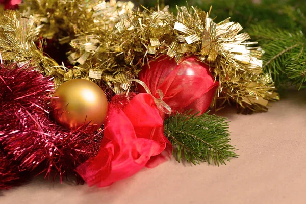 Abstract New Year and Christmas long horizontal background. Red and gold tinsel, a golden ball lies inside, the background is blurred. — Stock Photo, Image