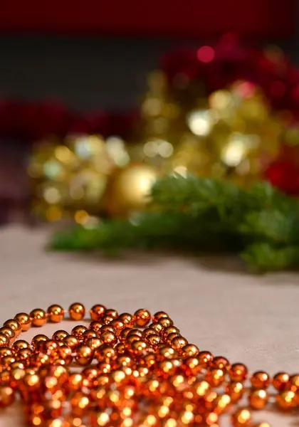 수공예 용지의 배경에는 오렌지 구슬, 금 및 붉은 티 셀 , 녹색 가문비나무 가지들이 있다. 장식용 장식, 새해와 크리스마스 장식 — 스톡 사진