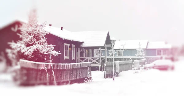 Wiejska ulica ze śnieżnymi domkami, domkami, dachami i ogrodzeniem w śniegu i mrozie. — Zdjęcie stockowe