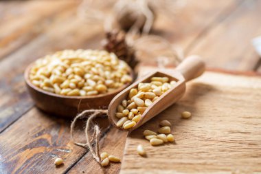 Hala bir kasede çam fıstığıyla dolu bir hayat. Masadaki tahta kesme tahtasının üzerinde fındıklı bir kepçe. Doğal malzemeden yapılmış bir ip..