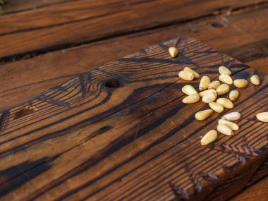 Üzerine çam fıstığı dökülen ahşap bir kesme tahtası.. 