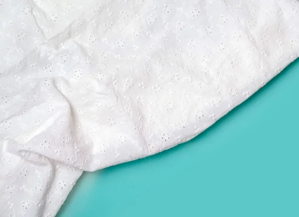 El fondo de la tela de algodón blanco con pliegues se encuentra en una superficie lisa azul. —  Fotos de Stock
