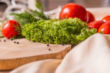 Salata için taze sebzeler, kesim tahtası ve masa örtüsü..