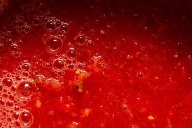 Domates suyu ve posası yakın plan. Yüzeyde farklı boyutlarda köpükler var.. 