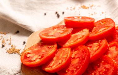 Tahtaya yakın plan domates dilimleri. Uzak arkaplan bulanık.