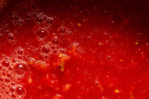 Sumo de tomate com close-up de polpa. Nas bolhas de superfície de diferentes tamanhos e espuma. — Fotografia de Stock