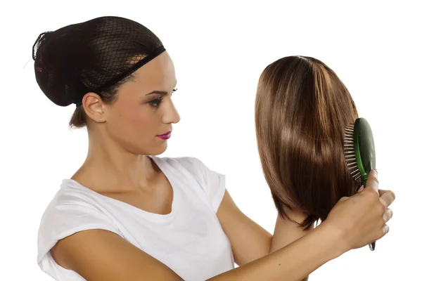 Mulher penteando sua peruca — Fotografia de Stock