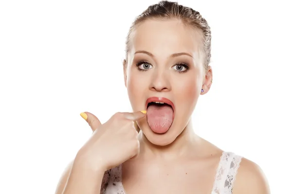 Pointing at her tongue — Stock Photo, Image