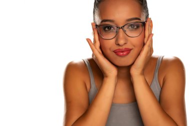 Beyaz arka planda gözlüklü mutlu, koyu tenli bir kadın.