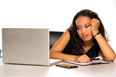 Beyaz arka planda dizüstü bilgisayarı ve penisi olan esmer, genç bir kadın.