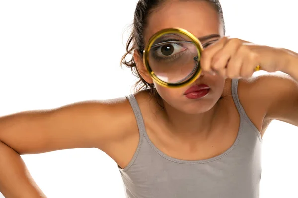 Een Verdachte Jonge Vrouw Kijkt Door Een Vergrootglas Witte Achtergrond — Stockfoto