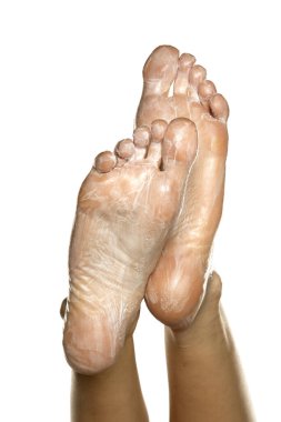 Beyaz arka planda ayak maskesi olan kadın ayakları.