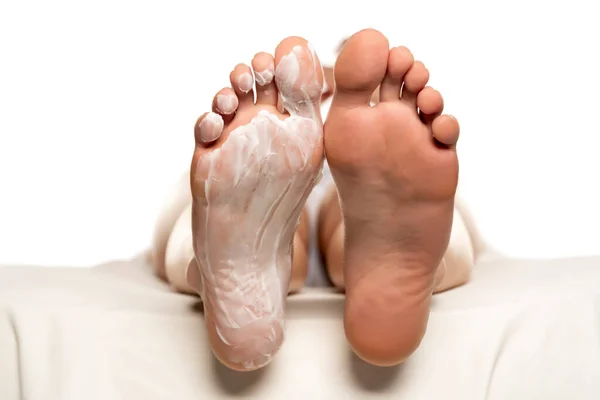 Female feet with foot mask on them on white background