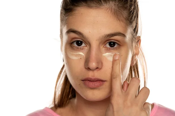 Wanita Muda Menerapkan Krim Wajah Bawah Matanya Pada Latar Belakang — Stok Foto