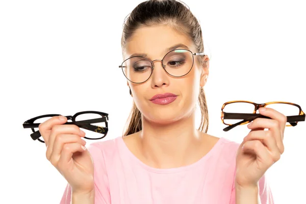 若い女性は白い背景に新しいメガネのフレームを選び — ストック写真