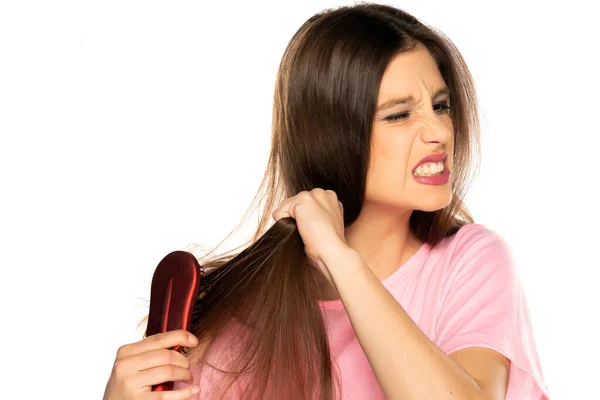 Jovem Mulher Nervosa Escovando Cabelo Fundo Branco — Fotografia de Stock