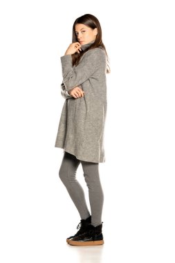 Beyaz arka planda gri ceketli güzel bir kadın.