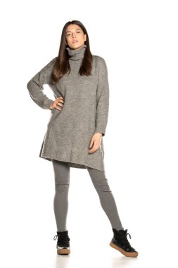 Beyaz arka planda gri ceketli güzel bir kadın.