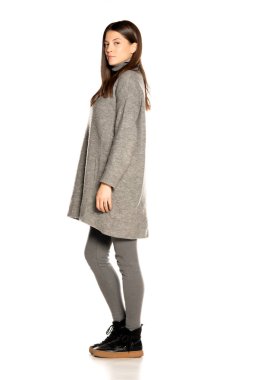 Beyaz arka planda gri ceketli güzel bir kadın.