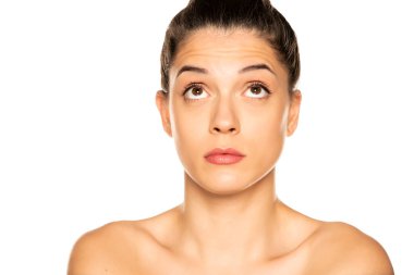  Genç ve güzel bir kadın beyaz arka plana bakıyor.