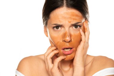 Yüzünde yanlış makyaj malzemesi olan hayal kırıklığına uğramış genç bir kadın.