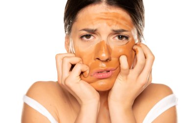 Yüzünde yanlış makyaj malzemesi olan hayal kırıklığına uğramış genç bir kadın.