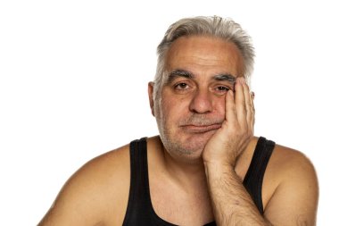 Tıraşsız, orta yaşlı, kısa gri saçlı bir adam.