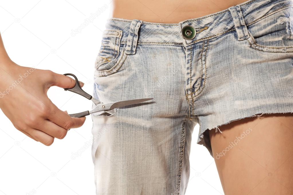 Girl cutting jeans