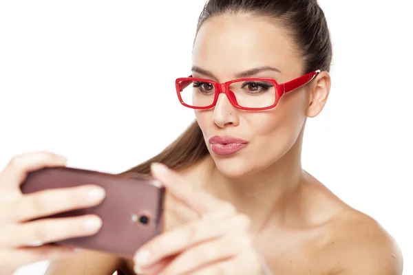 Frau mit roter Brille und Telefon — Stockfoto