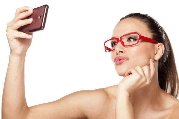 Femme avec des lunettes rouges et un téléphone — Photo