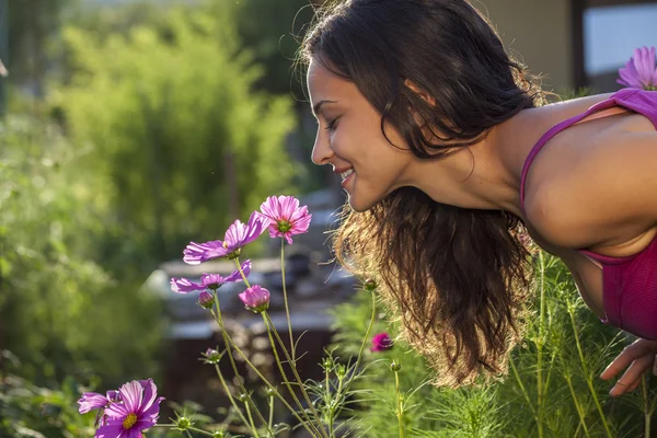 Mulher cheirando uma flor — Fotografia de Stock