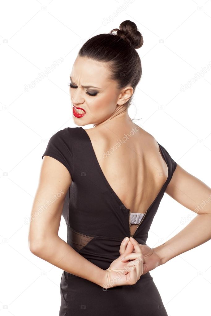 Woman unzipping her dress Stock Photo by 71597747