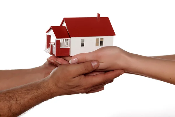 Mãos segurando casa em miniatura — Fotografia de Stock