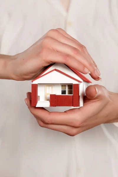 Mãos segurando casa em miniatura — Fotografia de Stock