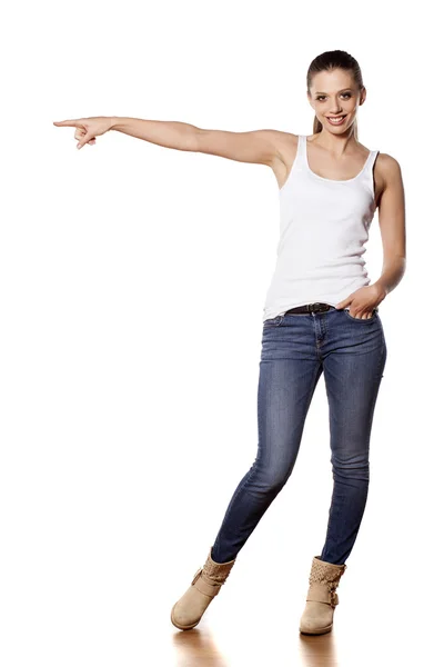 Girl in jeans pointing — Stock Photo, Image