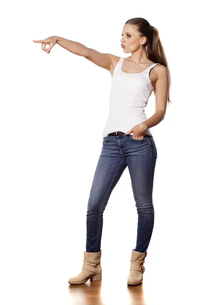 Menina em jeans apontando — Fotografia de Stock